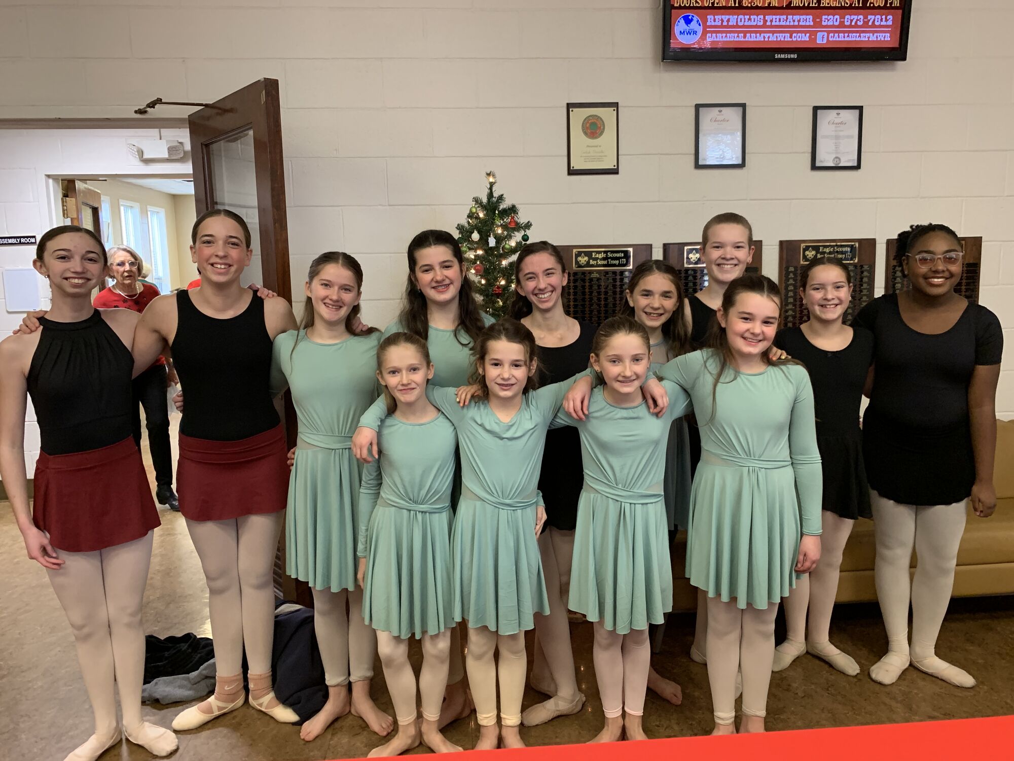 Teen performance team gathered by a Christmas tree before a show
