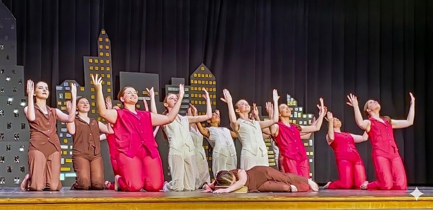 Dancers kneeling and reaching upward during a worship piece on stage